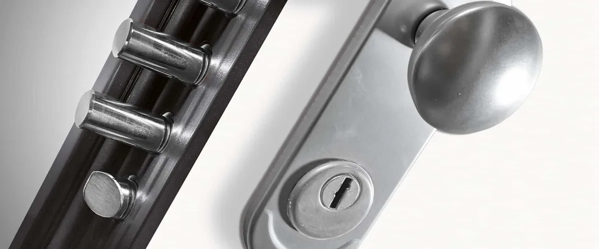 Canto de una puerta de seguridad con los cerrojos fuera y el pomo